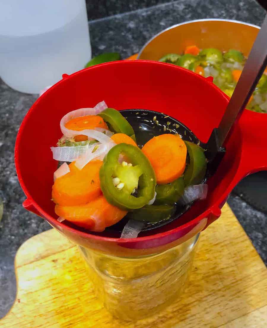 ladling vegetables into jars