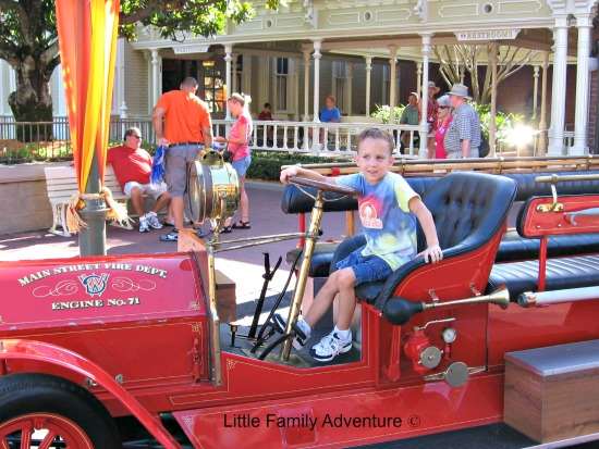 boy sitting on old red truck