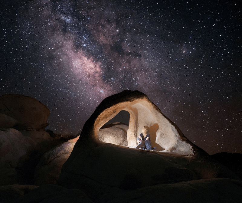 starry night and light inside rock formation