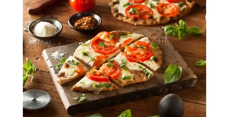flatbread pizza on slate with tomatoes and cheese