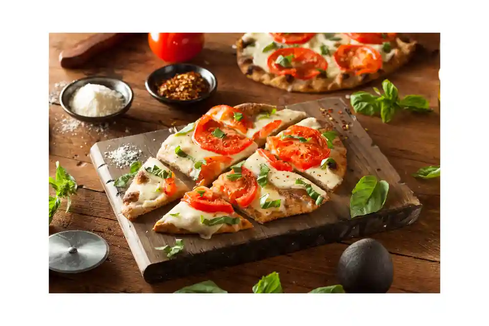 flatbread pizza on slate with tomatoes and cheese