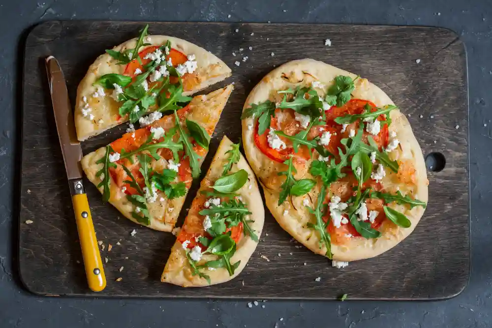 tomato arugula and feta flatbread on slate