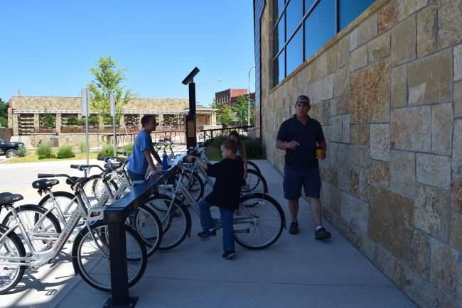 Renting bicycles lined up and man with two boys