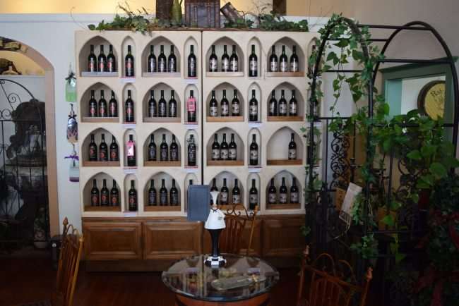 wall of wine bottles and greenery