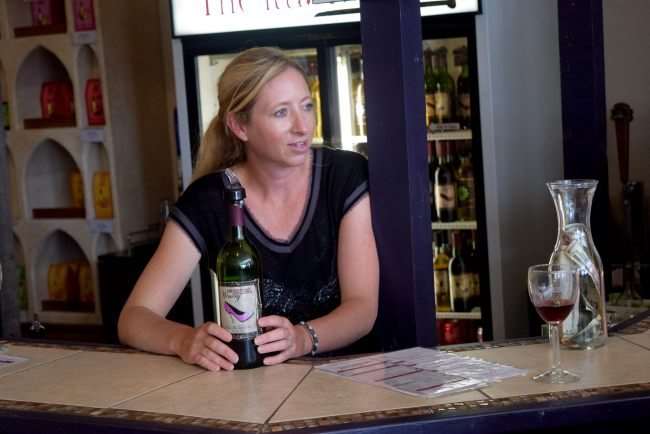 bartender with wine bottle at bar
