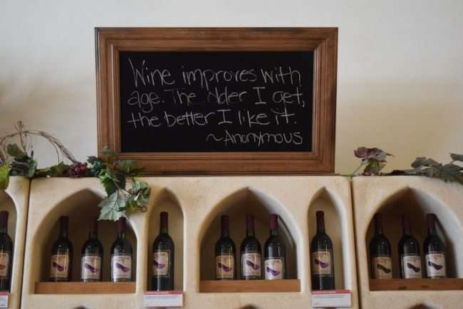 wall alcoves with wine bottles and chalkboard above