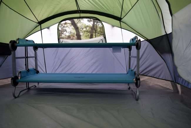 stacked camping cots in tent