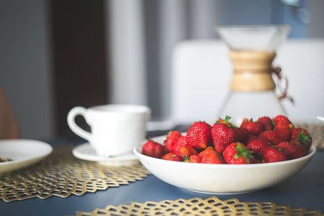 strawberries in a bowl, coffee cup