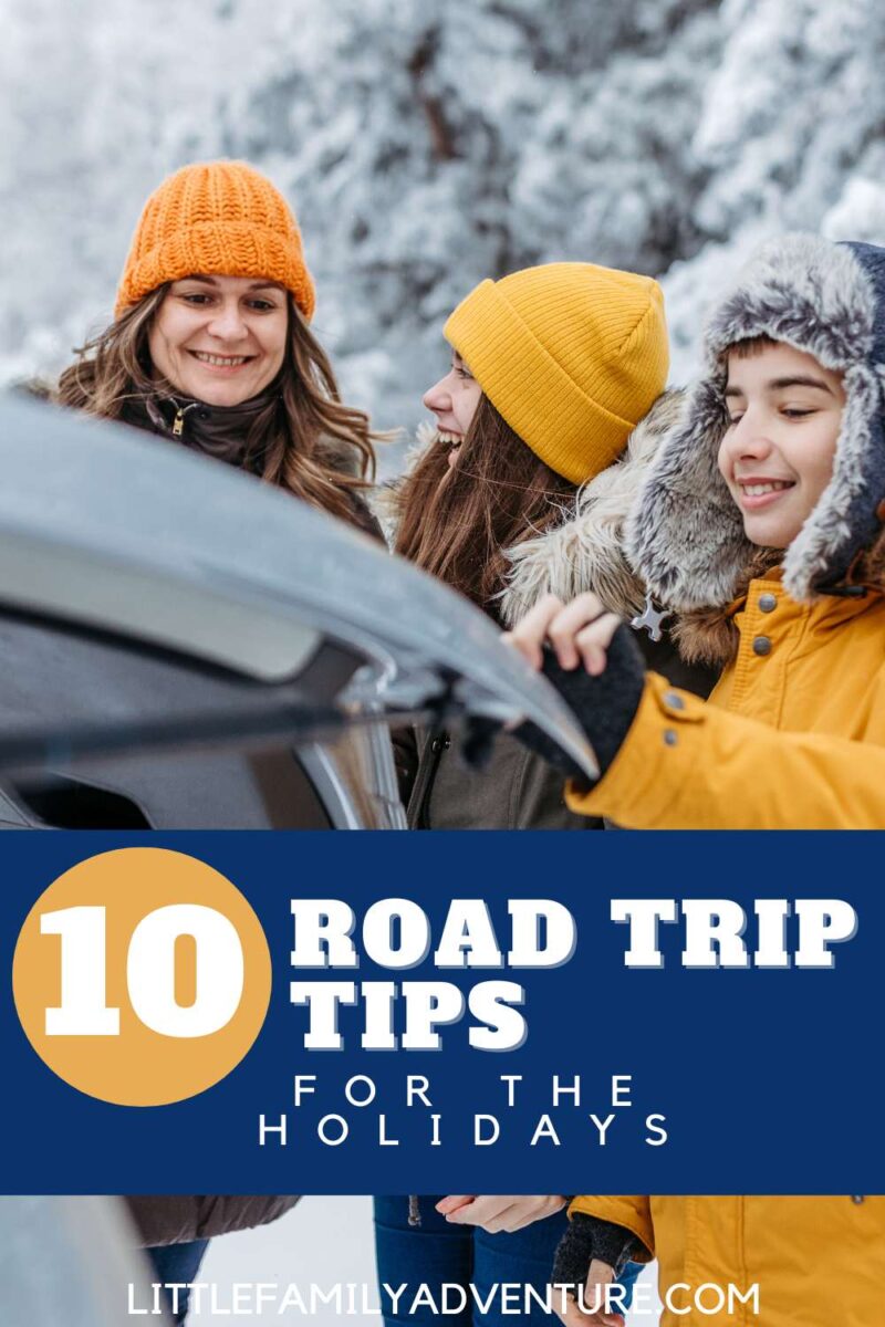mom with teens bundled in winter clothing opening trunk of car for holiday road trip