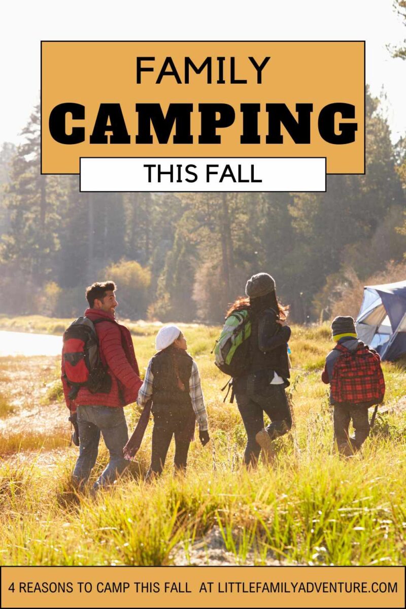 family hiking towards tent in autumn light