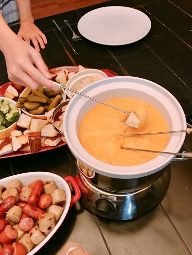 dipping bread in cheddar cheese fondue, dippers shown next to it