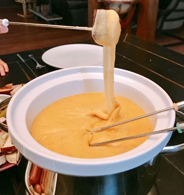 bread coasted on fondue above a fondue pot