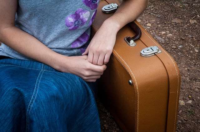 Woman leaning against suitcase