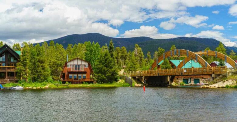 houses on shore of grand lake colorado with bridge and mountains