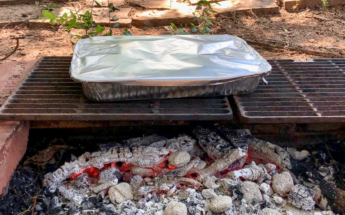foil covered pan over campfire coals