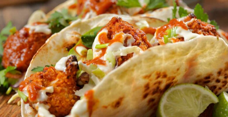 roasted buffalo cauliflower vegetarian tacos on plate with lime wedges