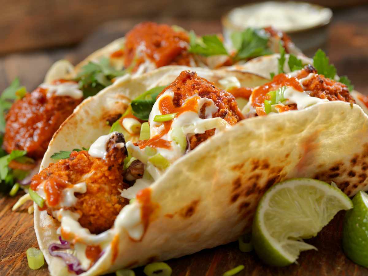 roasted buffalo cauliflower vegetarian tacos on plate with lime wedges
