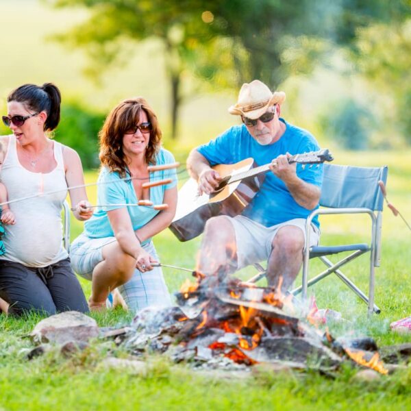 family camping and roasting weiners over campfire
