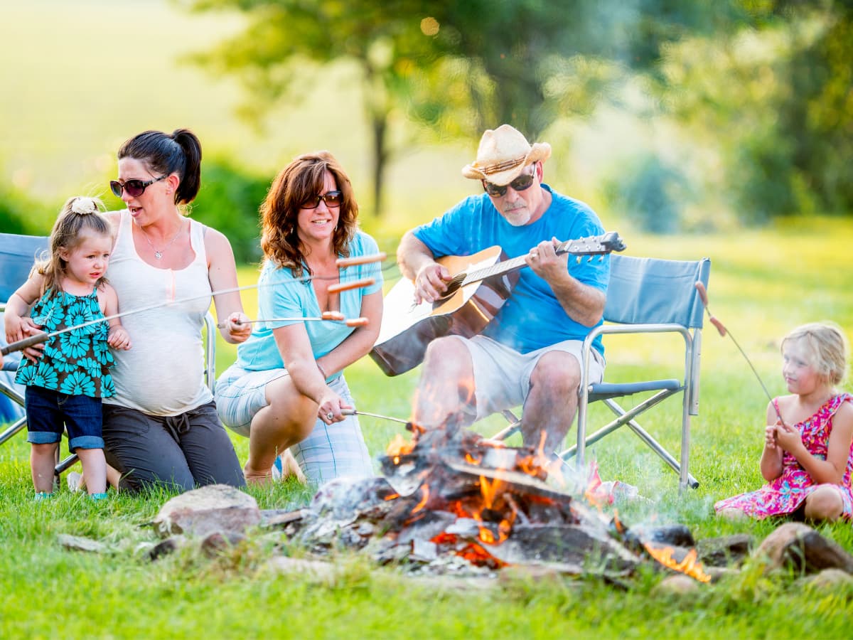 family camping and roasting weiners over campfire