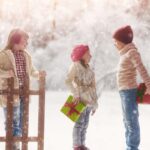 children in snow with gifts