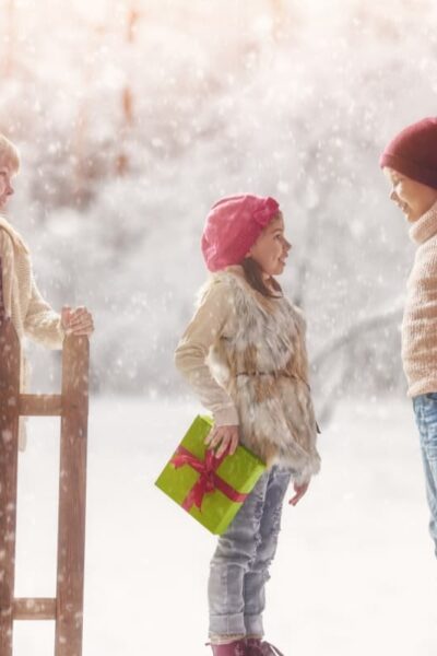 children in snow with gifts