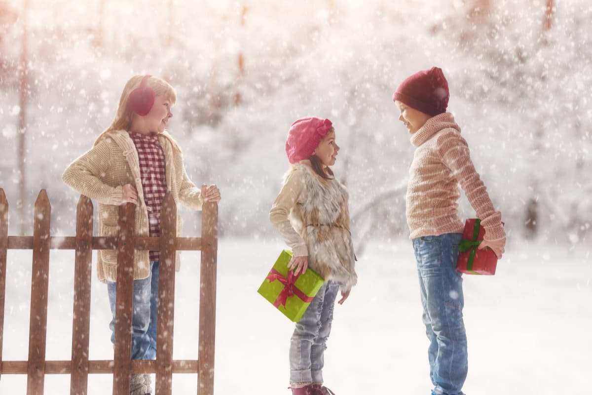 children in snow with gifts
