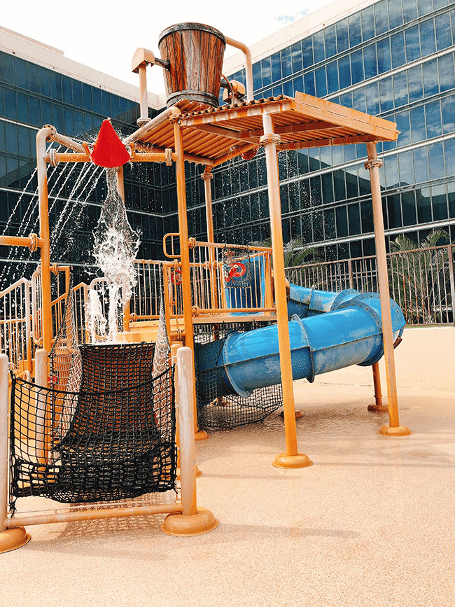 Water play area with a water slide and dump buckets