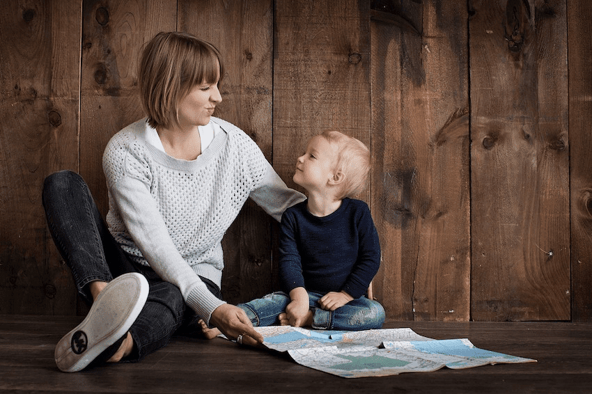 Mother and children looking at a map - Tips to Planning International Travel with Children as a Single Parent - Easy ways to plan your next trip aboard when your partner/spouse is staying home.