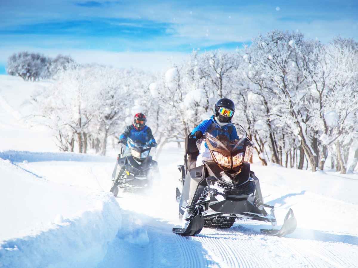 two people snowmobiling in a granby co winter