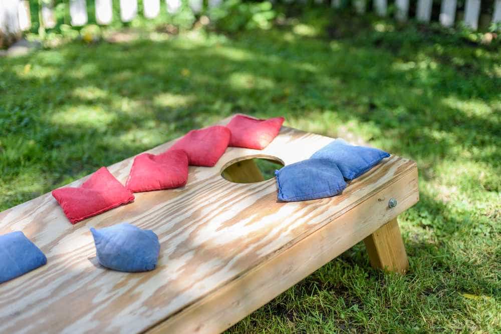 cornhole set with red and blue bags in the backyard