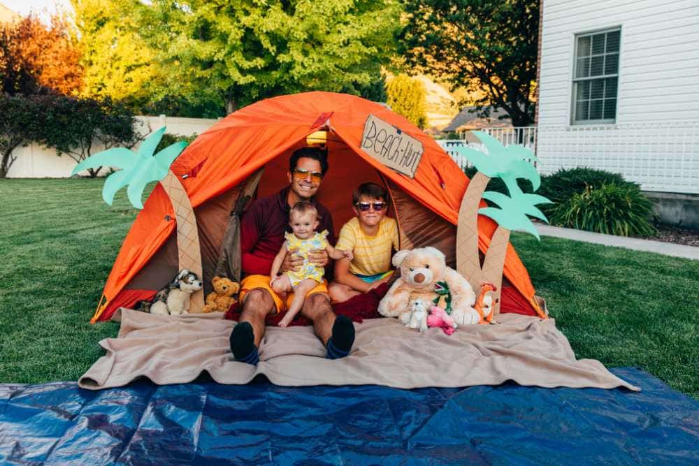 dad and kids in orange tent for backyard camping