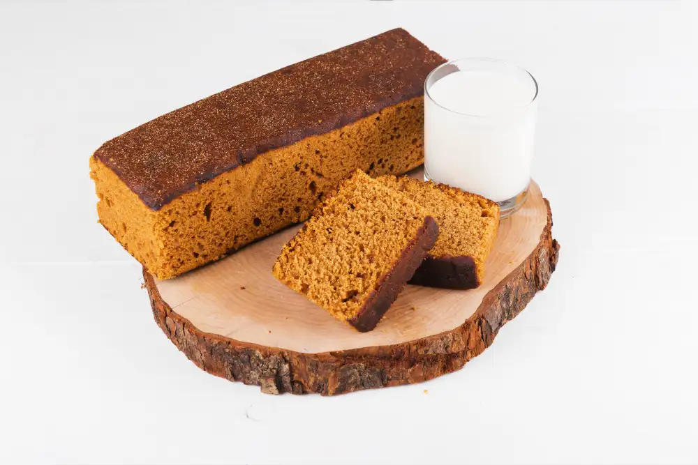 breakfast bread loaf and sliced with glass of milk on wooden cutting board