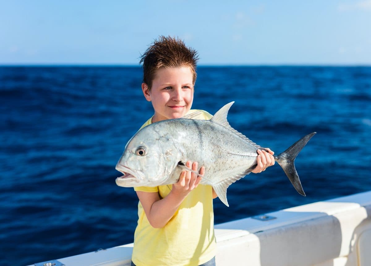 boy holding fish, deep sea