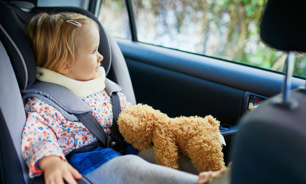 toddler in car seat with teddy bear