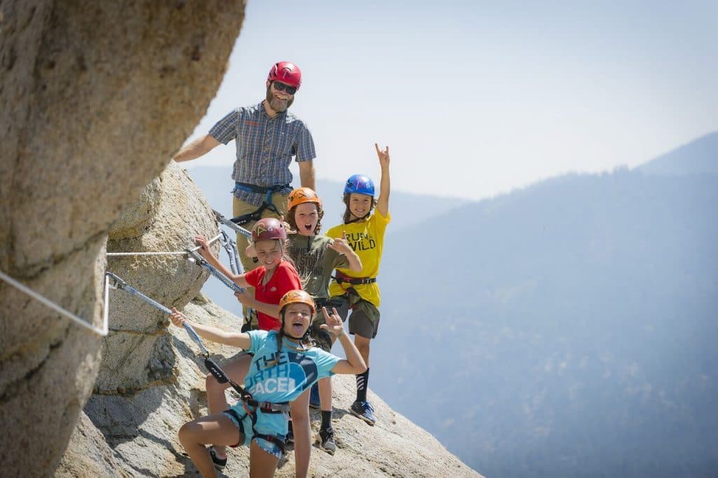 man and children on via Ferrata rock face - Lake Tahoe