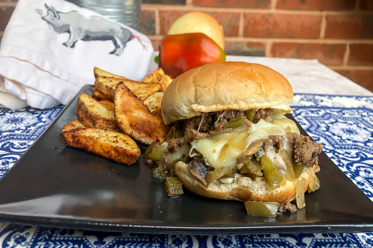 philly cheesesteak sloppy joe on plate with oven fries