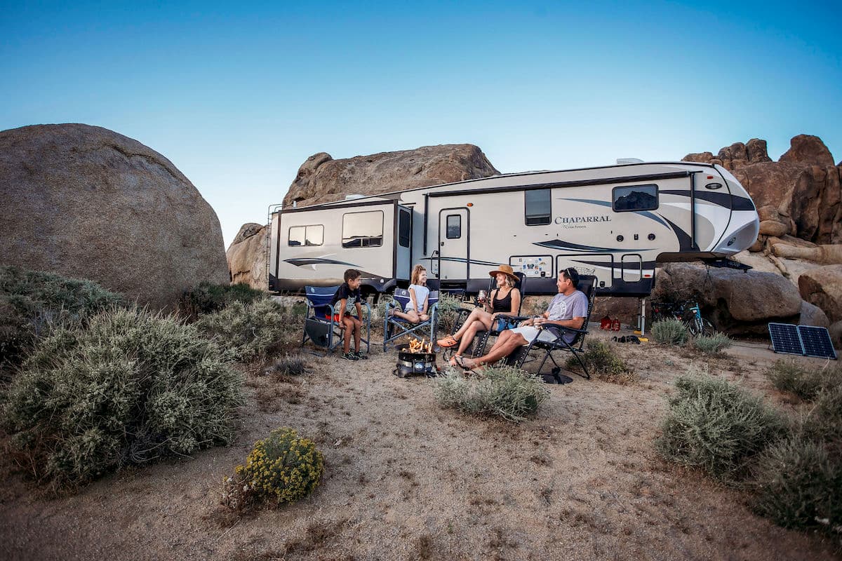 family in front of RV in desert