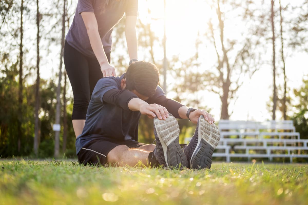 two people stretching in park
