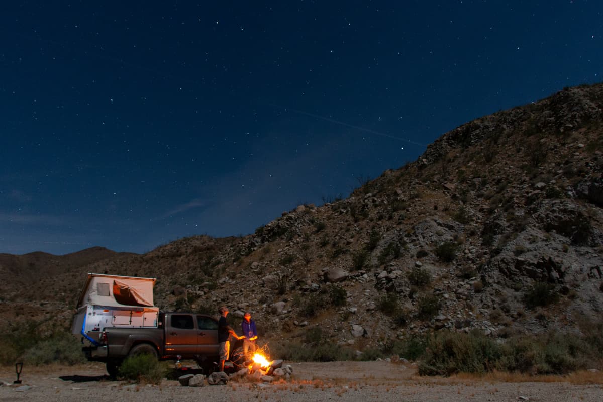 overland truck and people by campfire