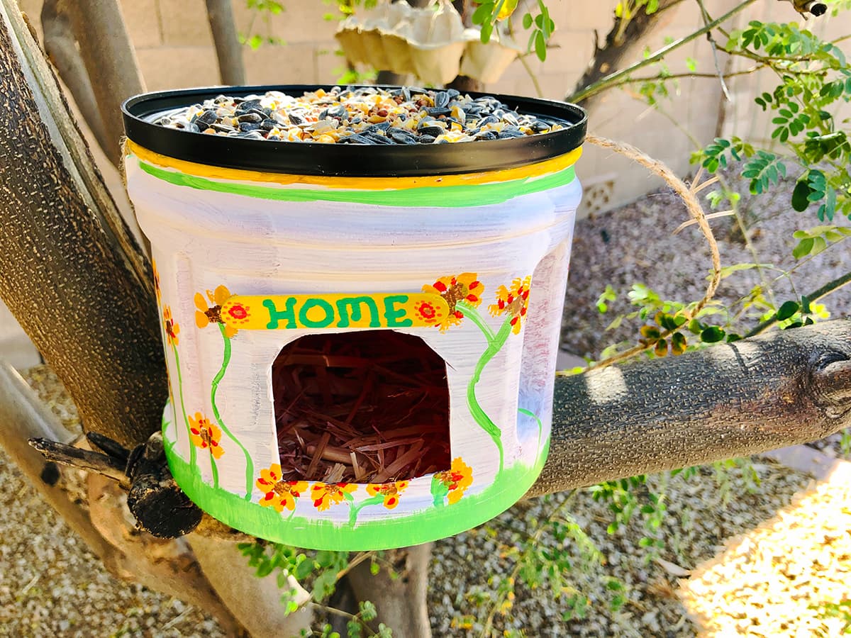 recycled coffee can bird feeder in tree