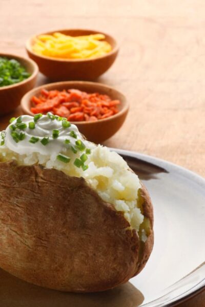 Baked potato bar with bacon, cheese, sour cream, and chive toppings