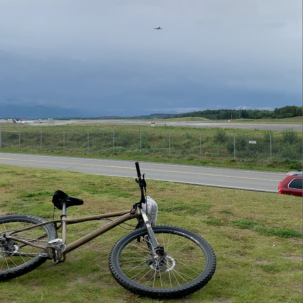 planes taking off with bike in foreground