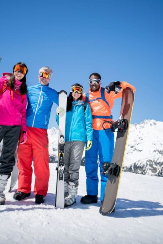 family dressed to go skiing holding their skiis, mountains and skiing, family travel