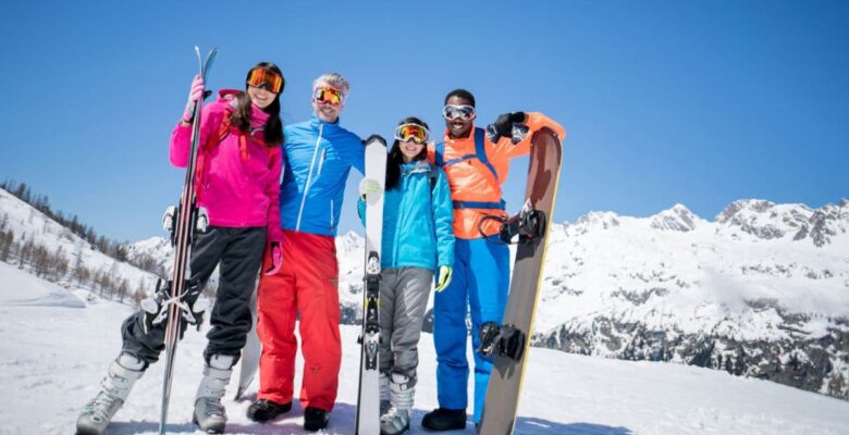 family dressed to go skiing holding their skiis, mountains and skiing, family travel