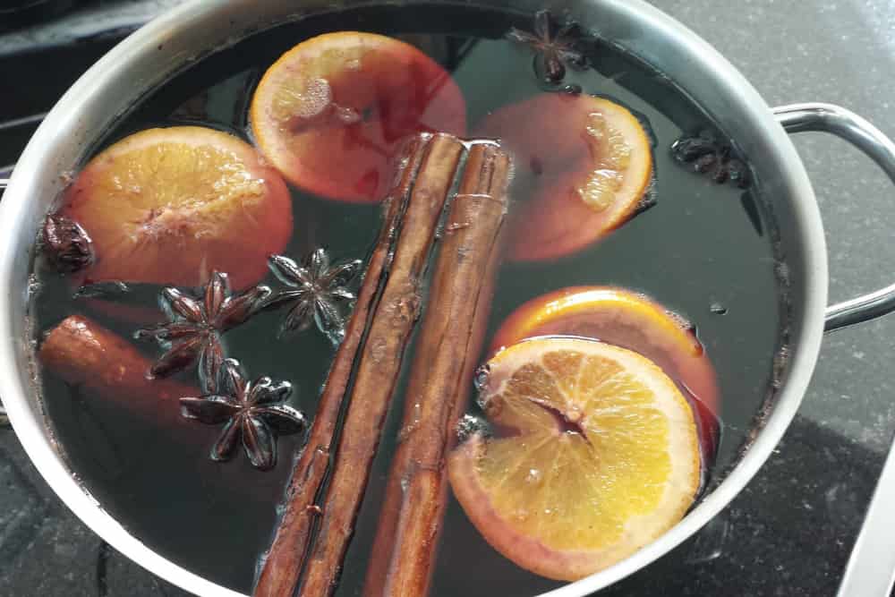 mulled wine, ornage slices, and spices in pot