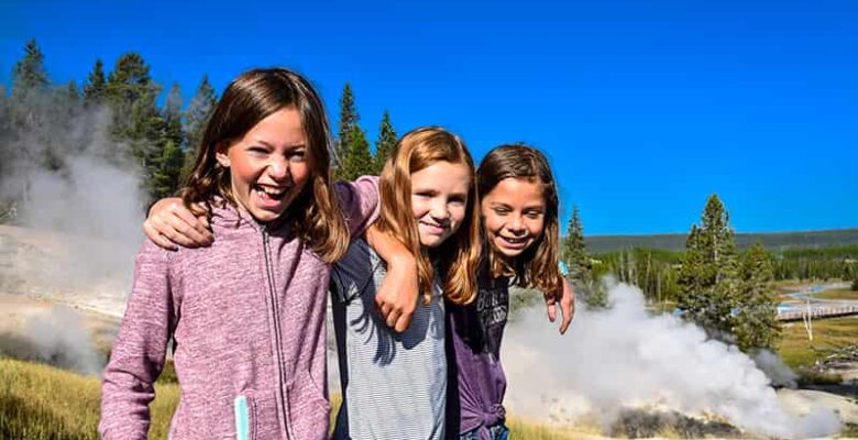 girls outside in front of geyser