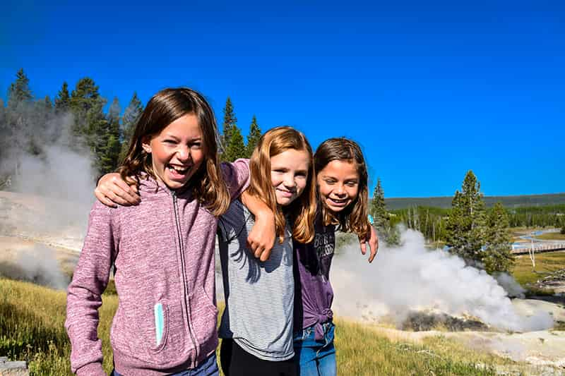 girls outside in front of geyser