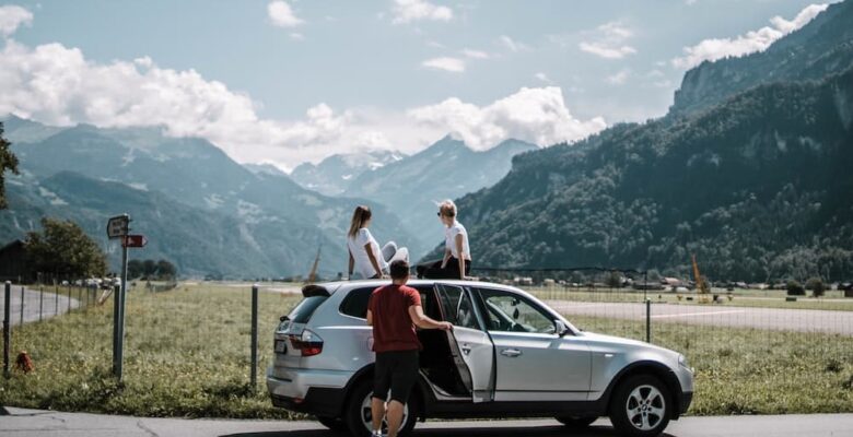 Family by car on road trip in mountains