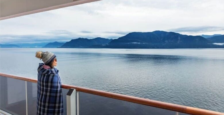 Woman with wool blanket on cruise ship balcony looking at Alaska's Inside Passage (1)