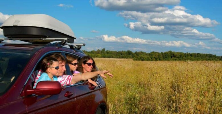 family looking out car windows at roadside attraction